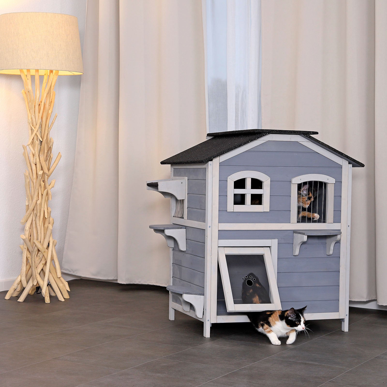 zwei Katzen sitzen im Katzenhaus im Wohnzimmer